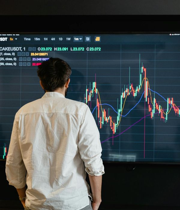 Financial analyst reviewing market trends and investment opportunities on multiple screens